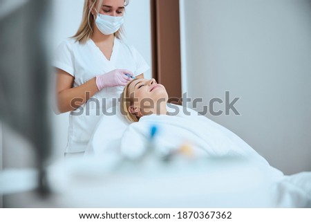 Young female patient undergoing the platelet-rich plasma therapy for hair loss in a beauty clinic Royalty-Free Stock Photo #1870367362