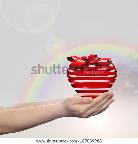 Concept or conceptual 3D red heart sign or symbol with ribbon held in hands by   a man, woman or child on rainbow sky background, metaphor for love, holiday, gift, care, valentine or romantic