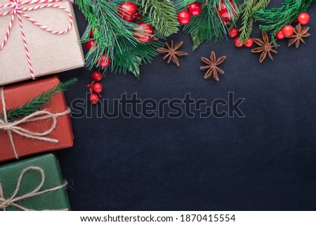 Top view above of Christmas holiday background. Composition with fir pine branches, Gift kraft box decorations on black background. Winter, Christmas, new year concept. Flat lay, copy space.