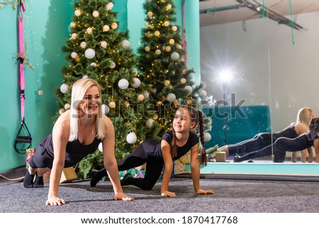 family doing fitness near the christmas tree