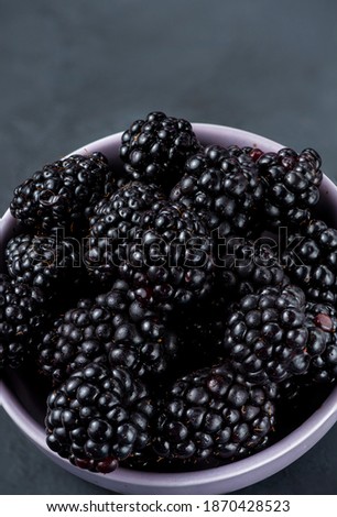 Many blackberries in a plate on a black background Stacked image Still life photography