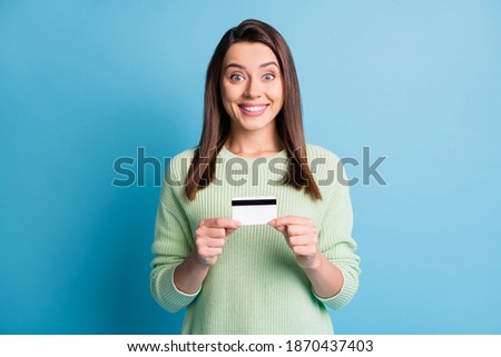 Photo portrait of woman cheerful girl holding plastic card with fingers isolated on pastel blue colored background