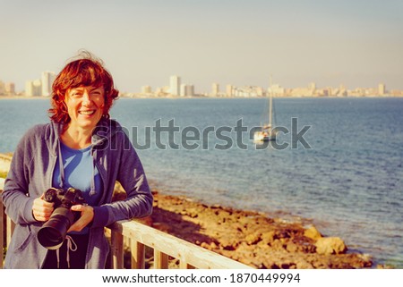 Tourist woman visit Cape Palos, Cartagen Murcia region, Spain. Female taking travel picture with professional camera, enjoy La Manga sea view.