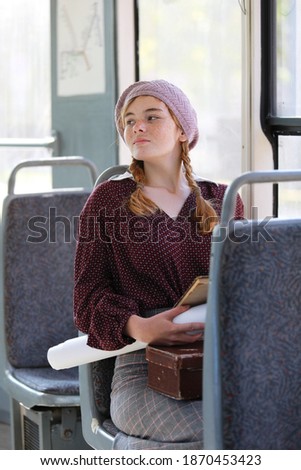 Charming girl in retro style clothes rides in an empty tram on a summer day
