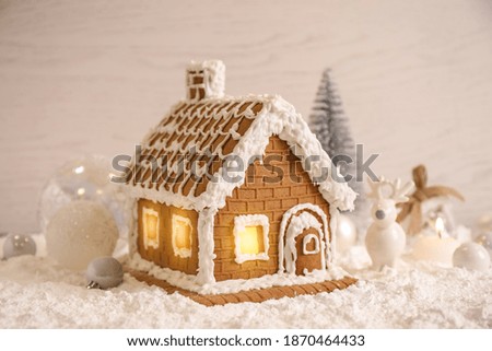 Beautiful gingerbread house decorated with icing on snow