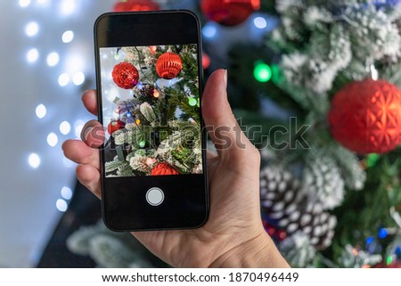take a vivid beautiful photo of the Christmas tree. Bloggers shoot for social media. Beautiful Christmas tree in the snow.