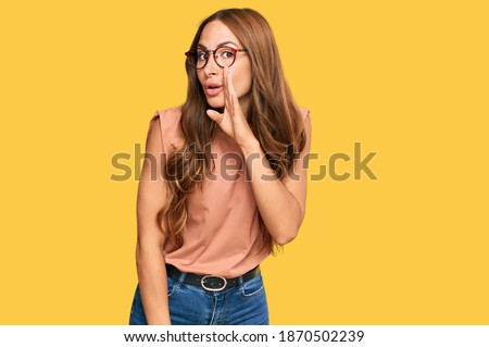 Young hispanic woman wearing casual clothes and glasses hand on mouth telling secret rumor, whispering malicious talk conversation  Royalty-Free Stock Photo #1870502239