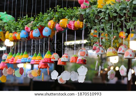 Cartoon  fancy colorful flowerpot with bells are hanging with tree decorated at local shop clay handmade 