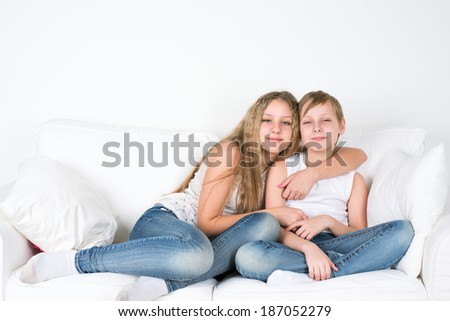 Sister and brother sitting embracing
