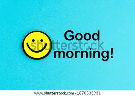 Good morning! Yellow emoticon on bright blue background. Good day wishes. Smile and positive