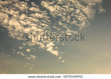 Fluffy white clouds on sky before sunset in the evening