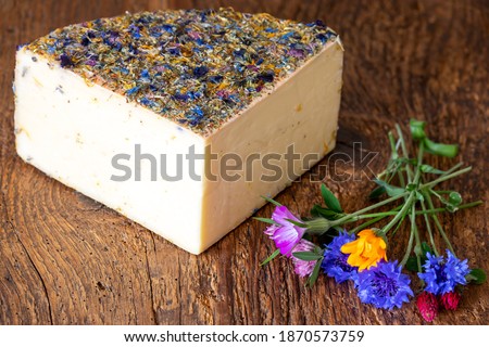 mountain cheese with flowers on wood Royalty-Free Stock Photo #1870573759