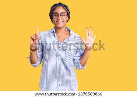 Young african american woman with braids wearing casual clothes and glasses showing and pointing up with fingers number six while smiling confident and happy. 
