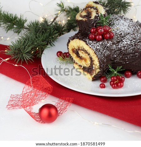 Chocolate Christmas Yule Log, Buche de Noel on white background. Christmas decorations.