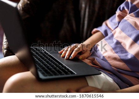 An Asian woman is using a laptop, she is browsing the Internet, she is chatting with colleagues, using technology ideas.