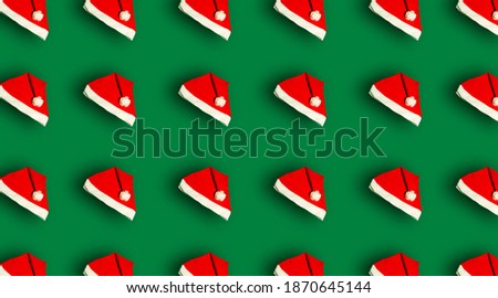 Christmas pattern with a Santa Claus hat on a green background. Prints and patterns.
