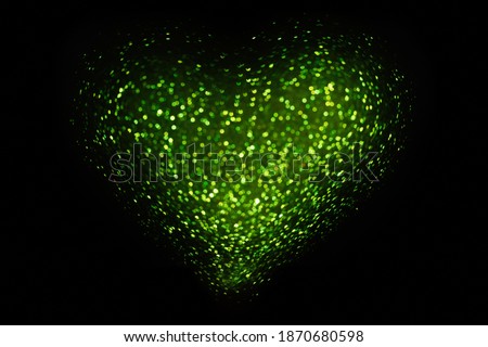 On black isolated background green defocused heart from bokeh. Greeting card. Texture for website, banner, poster. Template preparation for Valentine's, Mothers, St. Patrick's Day, March 8. Copy space