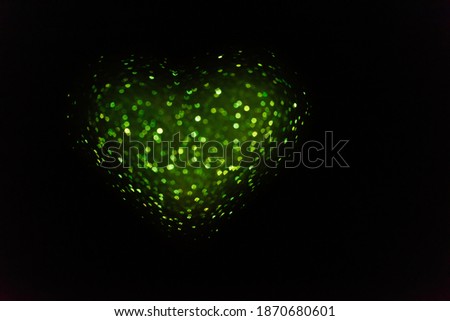 On black isolated background green defocused heart from bokeh. Greeting card. Texture for website, banner, poster. Template preparation for Valentine's, Mothers, St. Patrick's Day, March 8. Copy space