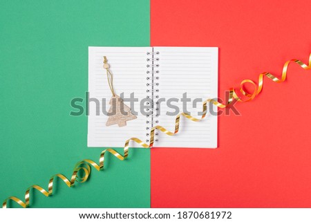Open blank notebook with place to add text, shopping cart and boxes on a bright red background. Online shopping concept