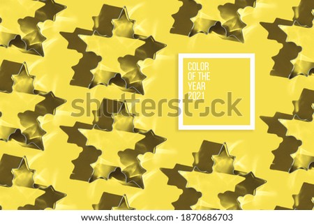 Forms for Christmas gingerbread cookies in the form of snowflakes, stars on trendy yellow illuminating background with hard shadow. Color of the year 2021.