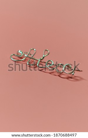 Metal brooch with the inscription name Alex on a pink background vertical