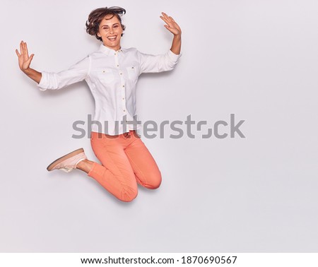 Young beautiful woman wearing casual clothes smiling happy. Jumping with smile on face and arms opened over isolated white background.
