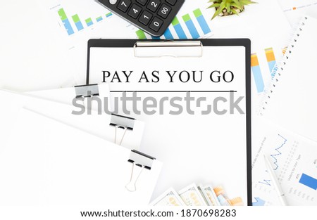 Paper plate, calculator, notepad,pen and pencils on the white background. Business concept. Text PAY AS YOU GO