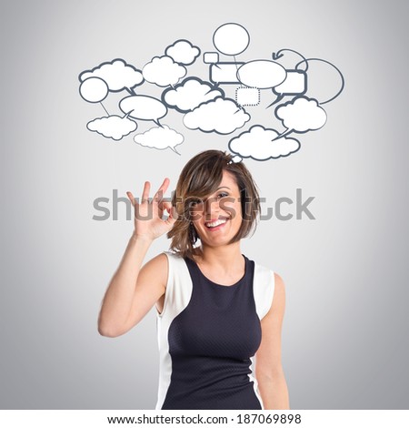 Pretty woman making Ok sign over grey background 