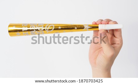 Hand is hold yellow paper Blow Horn for New Year and christmas party on white background.