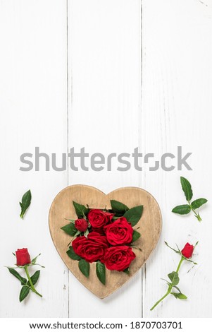 Valentine's day, love, romantic concept. Red roses and wooden heart on white background. Flat lay, top view, copy space.