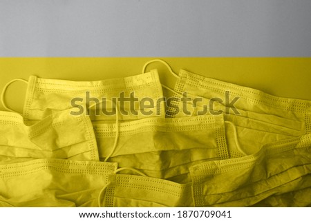 Medical mask lie on top of each other.Horizontal banner colored in grey and yellow colors.