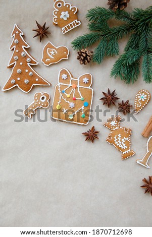 Christmas, New Year gingerbread composition. Christmas card with fur tree branch, gingerbread, cinnamon, anise on craft paper background. Place for text, top view  