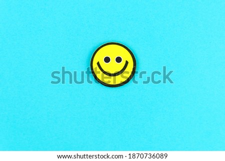 Yellow emoticon on bright blue background. Fools Day. Funny positive greeting card