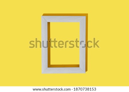 Frame for photo or painting on bright illuminating yellow background. Mockup. Place to insert text, images. Top view. Flat lay. Color of the year 2021.