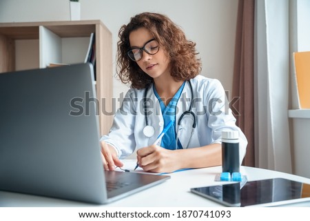 Attractive female doctor make online video call consult patient on laptop. Medical assistant young woman therapist videoconferencing to web camera. Telemedicine concept. Online doctor appointment. Royalty-Free Stock Photo #1870741093