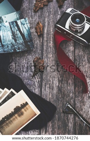
Exhibition of old camera and photos on dark cloth and red tape on old wooden board