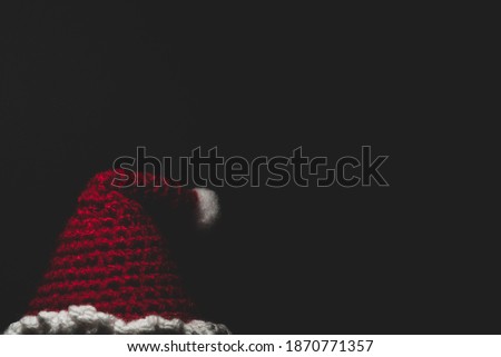 Portrait of Santa Claus Amigurumi crocheted or knitted stuffed toy on black background
