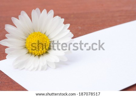 a white card with the flowers in the background for a message