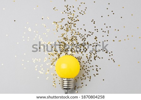 One decorative lamp on a light background with a scattering of sparkles of stars symbolizing the rays of light from the lamp. Conceptual photography.