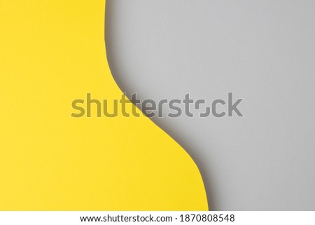 Bright yellow paper real texture background. Creative photo on the theme of the trending colors yellow and gray.