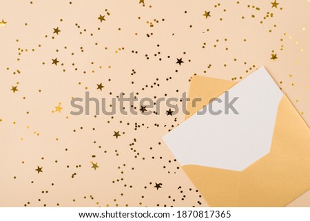 Flat lay close up layout view photo image of gold unwrapped envelope with clear card inside on shiny sparkling background with copy space