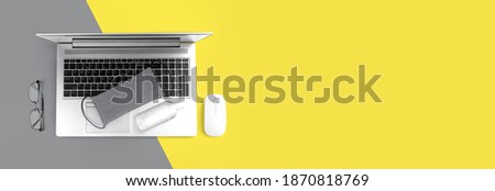Office computer gadget on Ultimate Gray and Illuminating yellow background. Color of the year 2021. Hygiene banner with protective medical mask, sanitizer. Virus protection stay home remote work