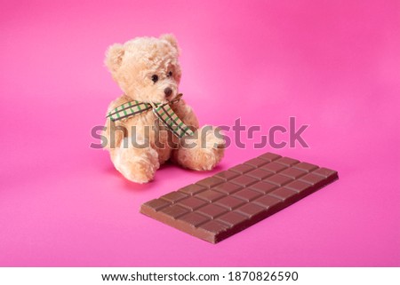 bear and milk chocolate on pink background
