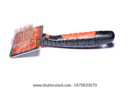 Comb for combing hair from an animal. In the comb is a bunch of Bengal cat hairs. Isolated white background