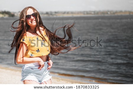 Beautiful caucasian woman with long hair posing on the beach.