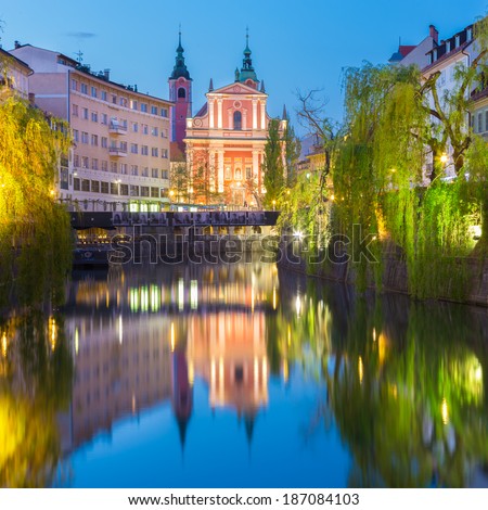 Romantic medieval Ljubljana's city center, capital of Slovenia, Europe. Night life on the banks of river Ljubljanica where many bars and restaurants take place. Franciscan Church in background