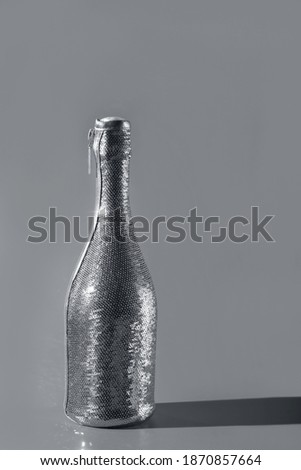 Modern design template with champaigne bottle covered in sequines in trendy grey color. Color 2021 concept. Holiday celebration concept. Modern template for your design.