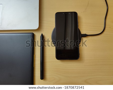 wireless charging smartphone on office table with empty copy space.