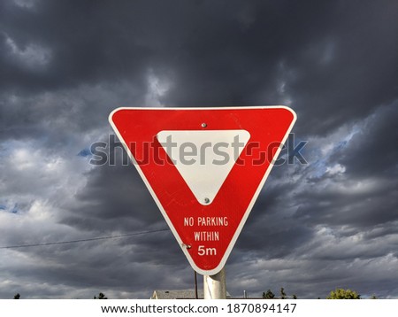 Yield Sign with dark clouds in background