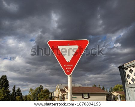 Yield Sign against dark clouds
